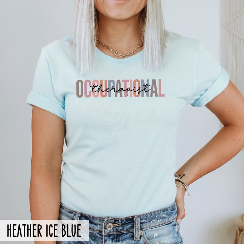 May include: A light blue t-shirt with the text "OCCUPATIONAL therapist" in colorful letters. The text is in a modern, handwritten font.