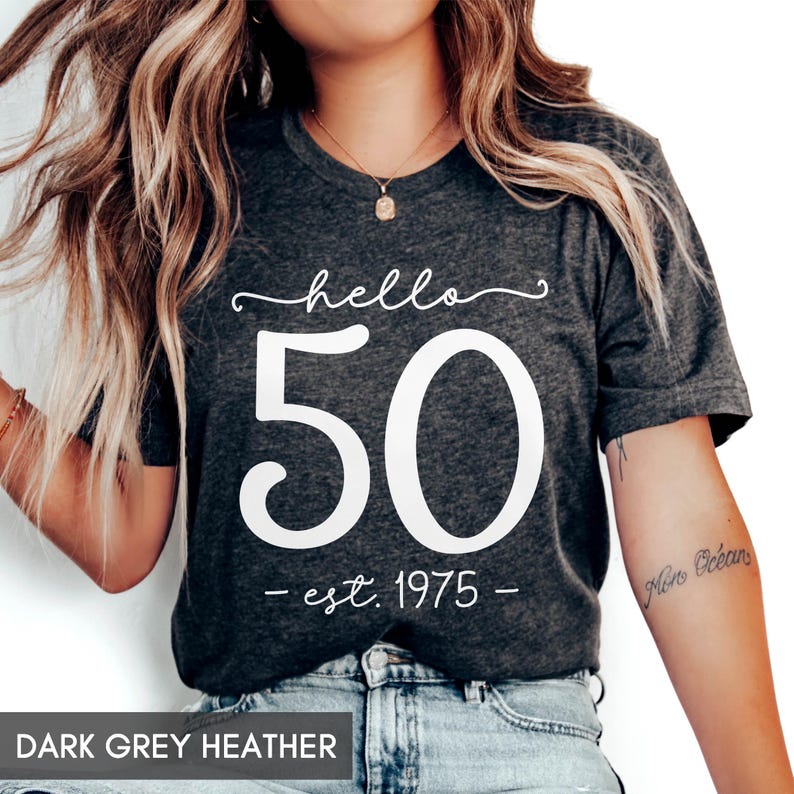 May include: Dark grey heather t-shirt with white text that reads "hello 50 - est. 1975 - "