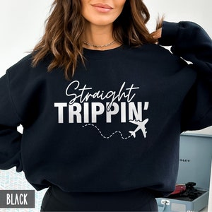 Puede incluir: Sudadera negra con texto blanco que dice "Straight Trippin'" y un gr&aacute;fico de avi&oacute;n blanco con un rastro de l&iacute;nea discontinua.
