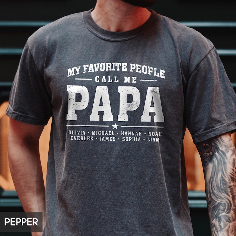 A man wearing a gray t-shirt with the text "MY FAVORITE PEOPLE CALL ME PAPA" printed on it.