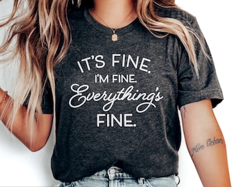 Könnte beinhalten: Dunkelgraues T-Shirt mit dem Text "It's fine. I'm fine. Everything's fine." in Weiß.
