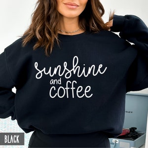May include: Black sweatshirt with white text that reads "sunshine and coffee".