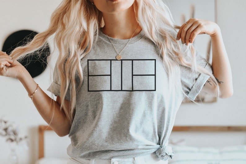 May include: A gray t-shirt with a black tennis court graphic design.