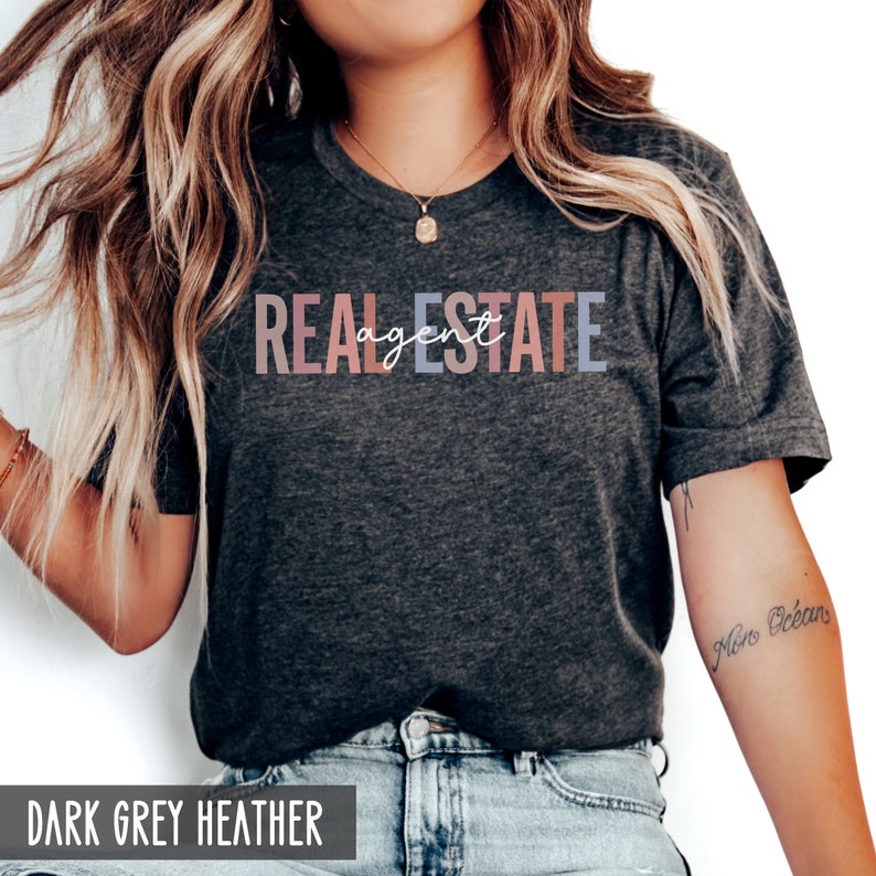 Peut inclure: Un t-shirt gris chin&eacute; fonc&eacute; avec le texte "REAL ESTATE agent" en d&eacute;grad&eacute; arc-en-ciel.