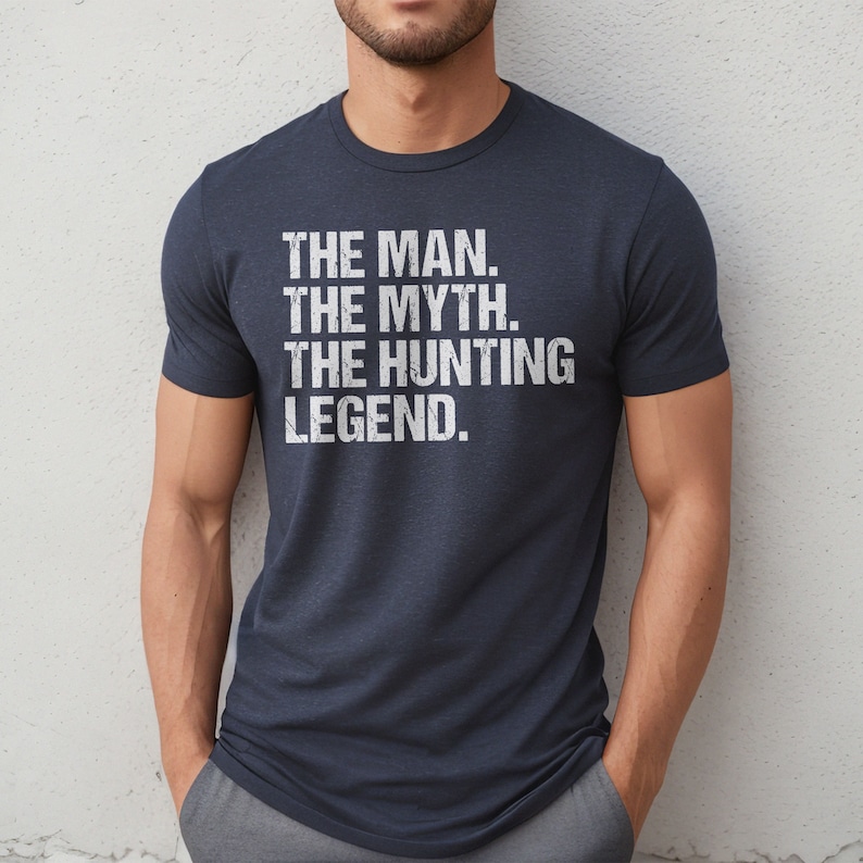 May include: A navy blue t-shirt with a white distressed graphic that reads "THE MAN. THE MYTH. THE HUNTING LEGEND."