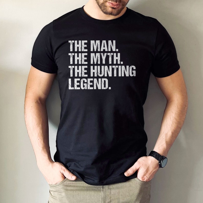 May include: A black t-shirt with white text that reads "THE MAN. THE MYTH. THE HUNTING LEGEND."