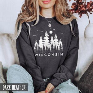 May include: Dark heather grey sweatshirt with a white graphic of a moon and trees with the word "WISCONSIN" underneath.
