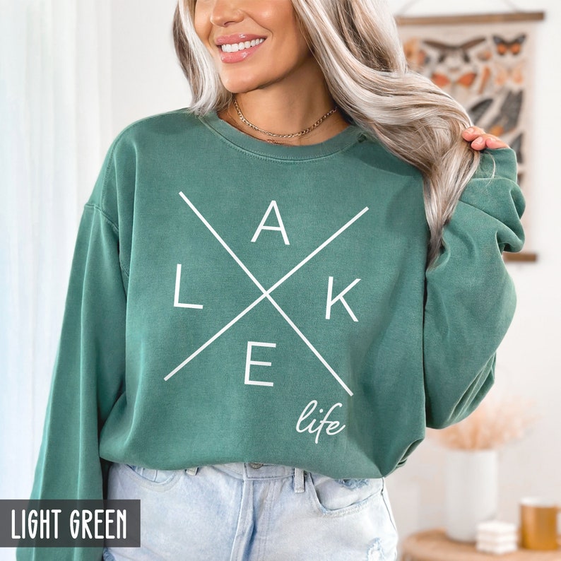 May include: A light green sweatshirt with a white graphic that says "LAKE life" with the letters forming a cross.