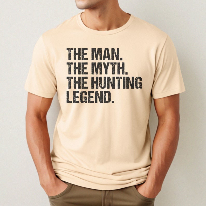May include: A beige t-shirt with the text "THE MAN. THE MYTH. THE HUNTING LEGEND." printed in black.
