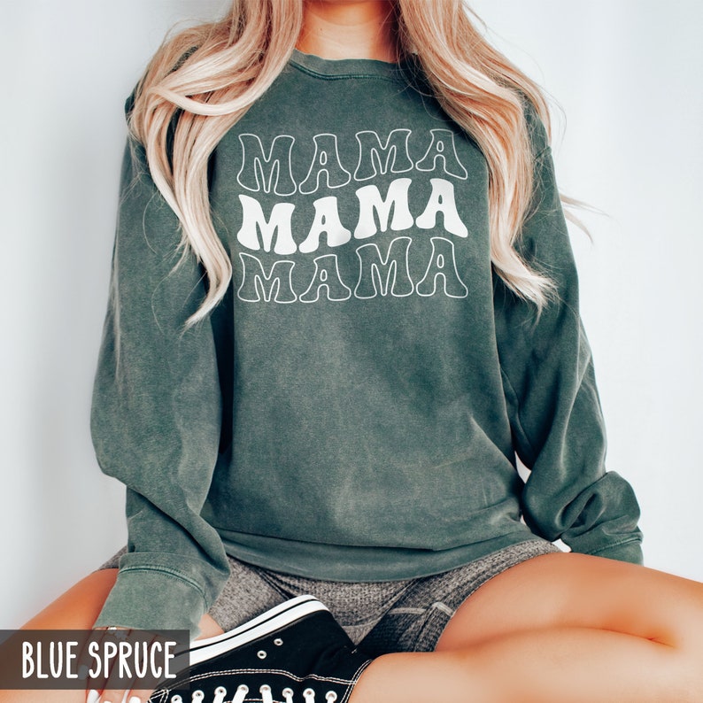 May include: A green sweatshirt with the text "MAMA" repeated three times in a retro font style.