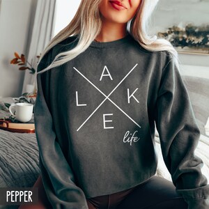 May include: A dark gray sweatshirt with a white graphic design that says "LAKE life" with the letters "LAKE" arranged in a cross pattern.