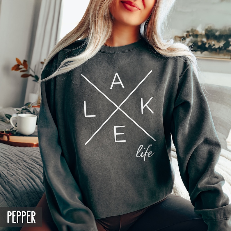 May include: A dark gray sweatshirt with a white graphic design that says "LAKE life" with the letters "LAKE" arranged in a cross pattern.
