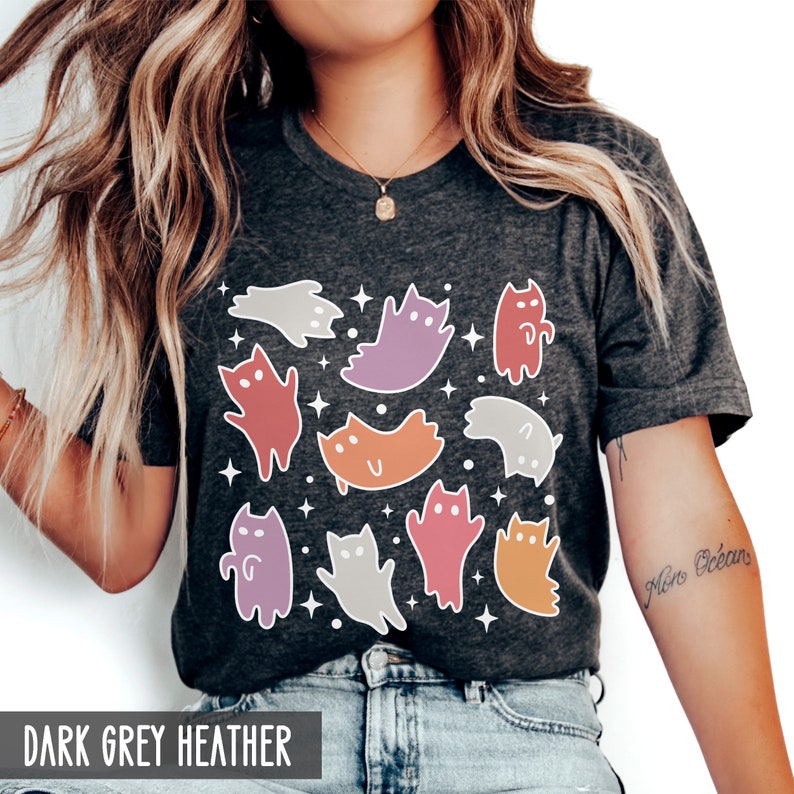 Op de afbeelding: Een donkergrijs heather t-shirt met een kleurrijke grafische print van katten en geesten. De grafiek bevat een verscheidenheid aan kleuren, waaronder paars, oranje, roze en rood.