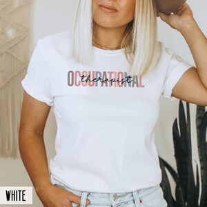 May include: White t-shirt with the text "OCCUPATIONAL therapist" in colorful letters.