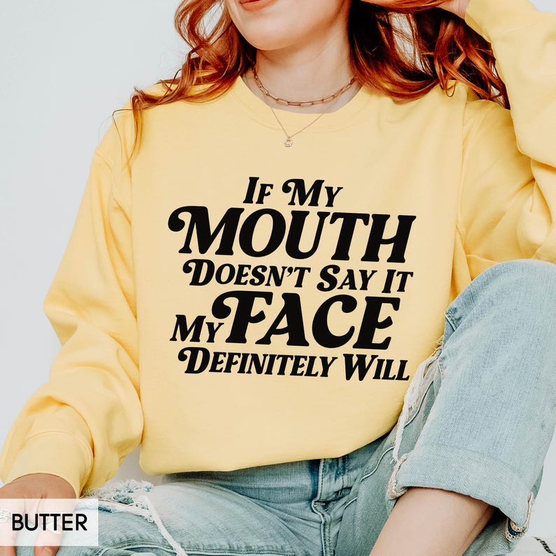 Puede incluir: Sudadera de color mantequilla con el texto negro "If My Mouth Doesn't Say It My Face Definitely Will". La sudadera de manga larga tiene cuello redondo. La palabra "BUTTER" est&aacute; en la esquina inferior izquierda.