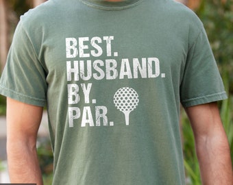 May include: A green t-shirt with a white distressed graphic that reads "BEST. HUSBAND. BY. PAR." with a golf ball and tee.