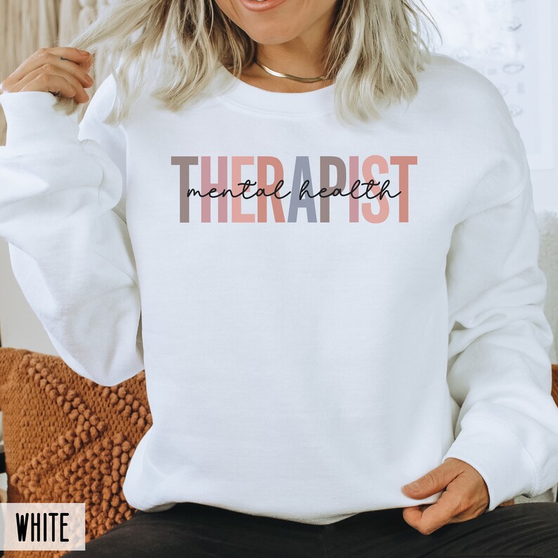 May include: White sweatshirt with the text "THERAPIST mental health" in colorful letters.