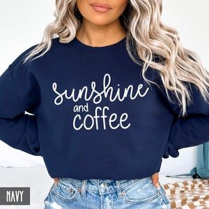 May include: A navy blue sweatshirt with the text "sunshine and coffee" in white lettering.