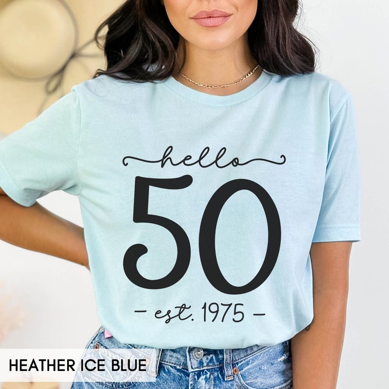 May include: A light blue t-shirt with the text "hello 50 - est. 1975 -" printed in black.