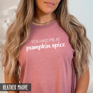 Pode incluir: Uma camiseta cor malva com o texto "You had me at pumpkin spice" em branco.