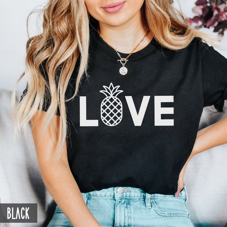 May include: Black t-shirt with a white pineapple graphic and the word "LOVE" in white letters.
