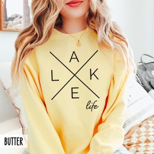 May include: A yellow sweatshirt with a black graphic design that says "LAKE life" with the letters in a cross shape.