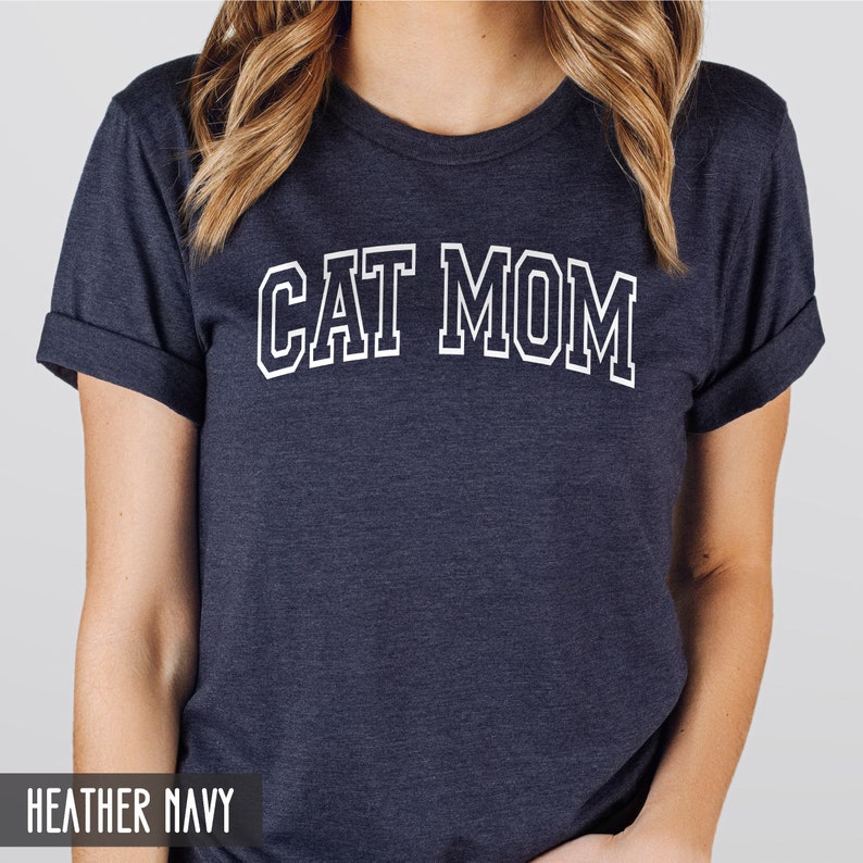 May include: A heather navy blue t-shirt with the text "CAT MOM" in white outlined letters.