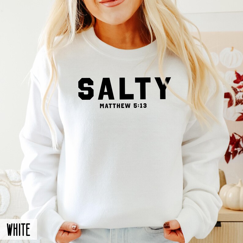 May include: White sweatshirt with black text that reads "SALTY" and "MATTHEW 5:13".