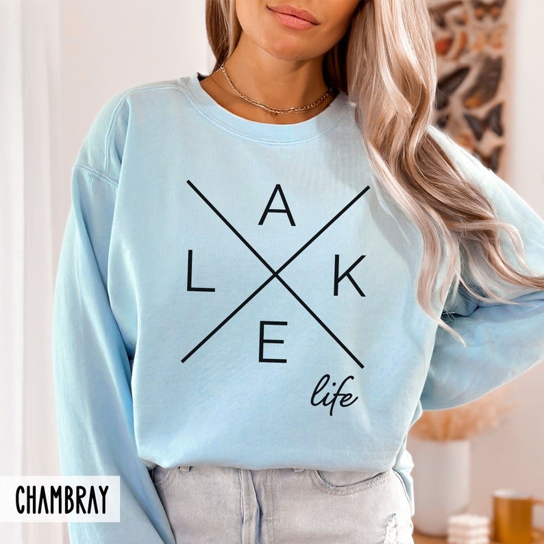 May include: Light blue sweatshirt with a black graphic design that says "LAKE life" with the letters forming a cross.