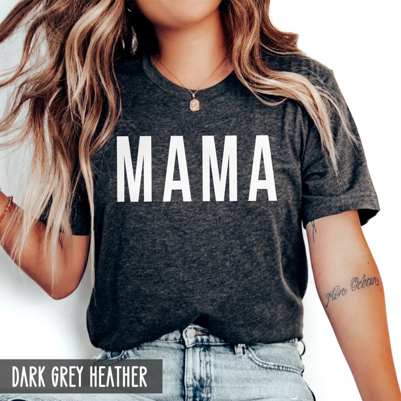May include: A dark grey heather t-shirt with the word "MAMA" printed in white on the front.