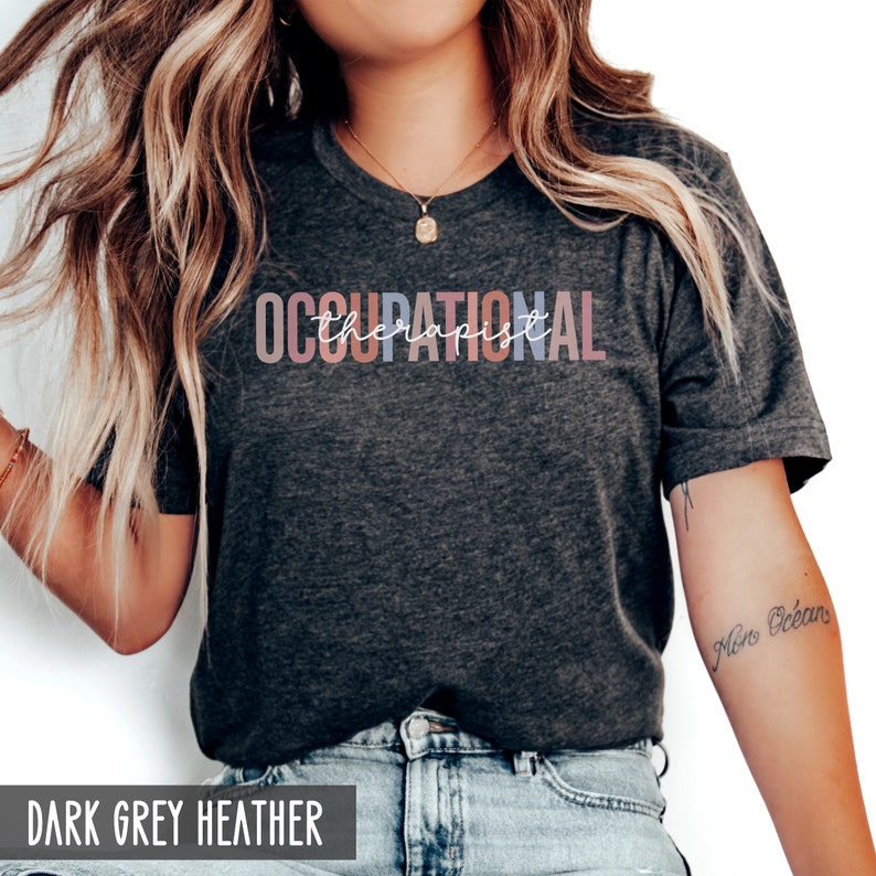 May include: A dark grey heather t-shirt with the text "OCCUPATIONAL therapist" printed in colorful letters.