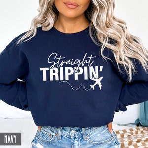 Puede incluir: Sudadera azul marino con texto blanco que dice "Straight Trippin'" y un gr&aacute;fico de avi&oacute;n blanco.