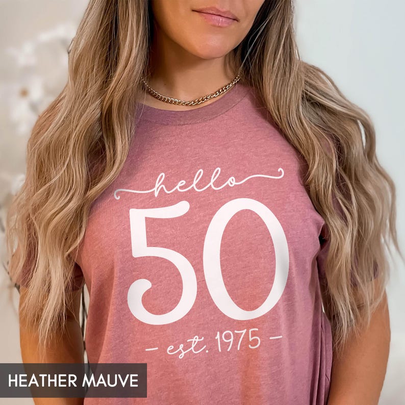 May include: Heather mauve t-shirt with white text that reads "hello 50 - est. 1975 -"