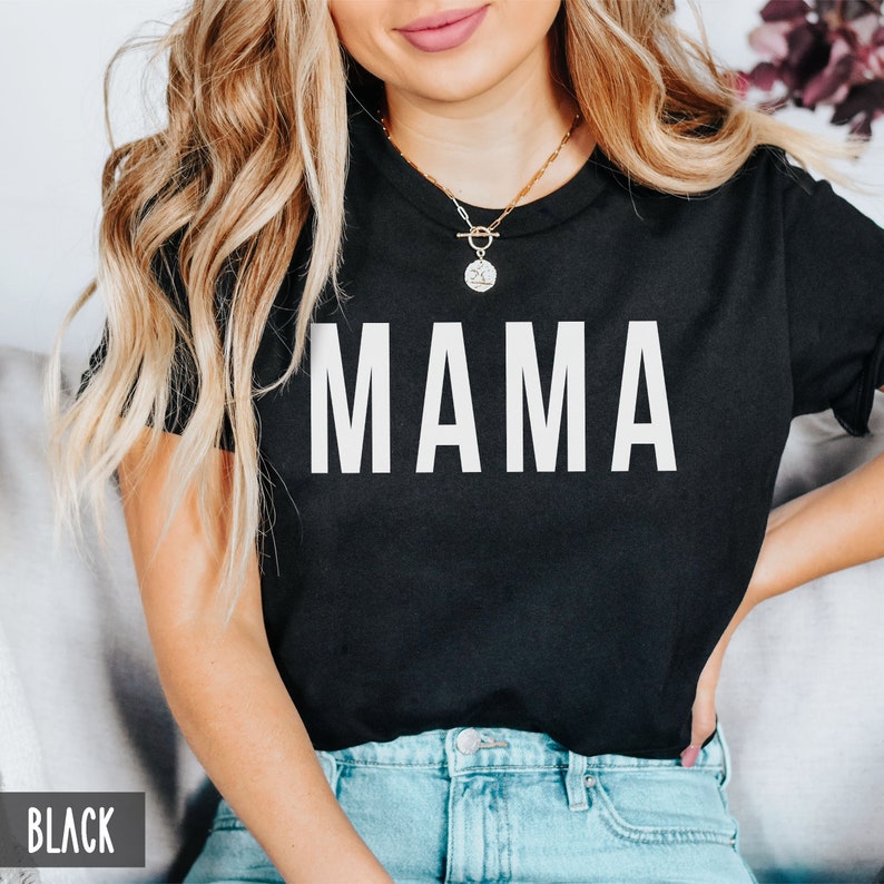 May include: A black t-shirt with the word "MAMA" printed in white on the front.