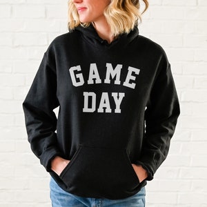 May include: Black hooded sweatshirt with the text "GAME DAY" in white letters.