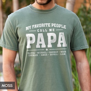 A man wearing a green t-shirt with the text "MY FAVORITE PEOPLE CALL ME PAPA" printed on it.