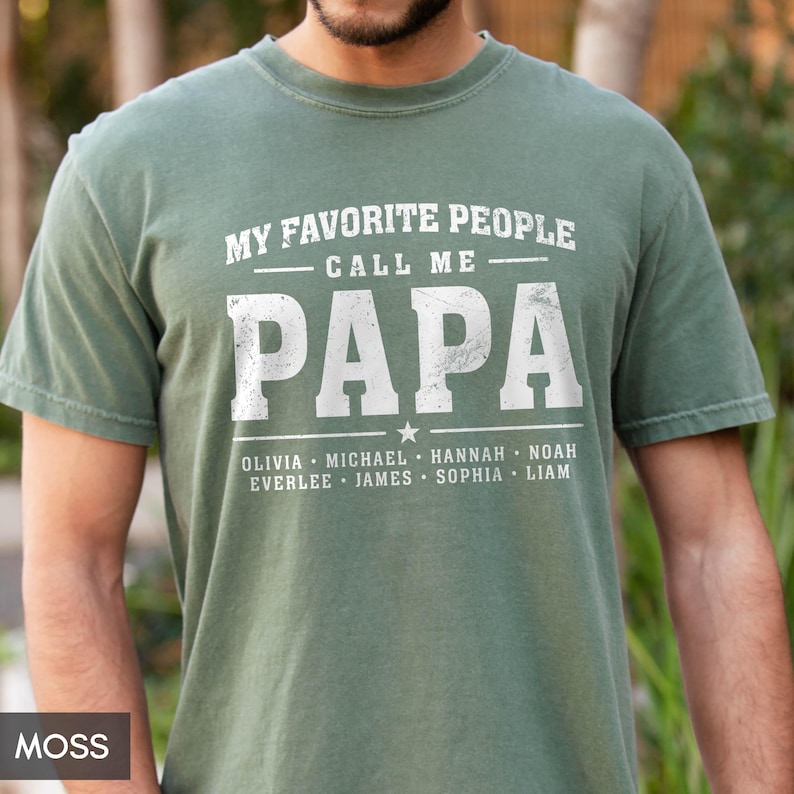A man wearing a green t-shirt with the text "MY FAVORITE PEOPLE CALL ME PAPA" printed on it.