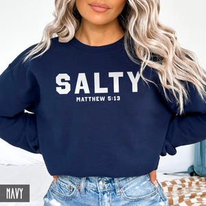 May include: Navy blue sweatshirt with white text that reads "SALTY" and "MATTHEW 5:13".