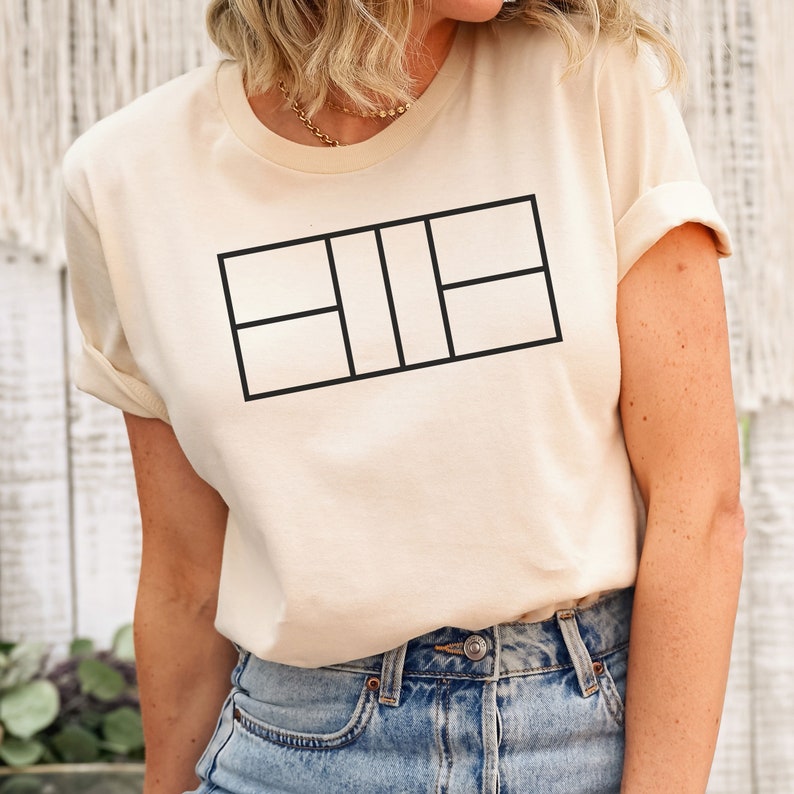 May include: A cream-colored t-shirt with a black tennis court graphic design.