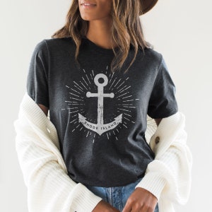 May include: A dark grey t-shirt with a white anchor graphic and the text "RHODE ISLAND".