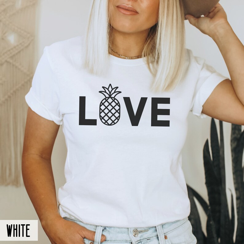 May include: White t-shirt with a black pineapple graphic and the word "LOVE" printed on the front.
