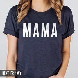 May include: A heather navy blue t-shirt with the word "MAMA" printed in white on the front.