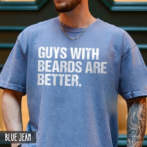 May include: A blue t-shirt with the text "Guys with beards are better." printed in white.
