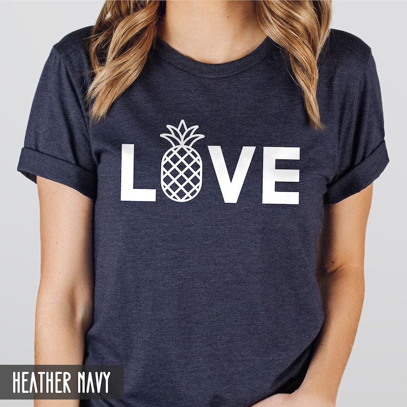 May include: A heather navy blue t-shirt with a white pineapple graphic and the word "LOVE" printed on the front.