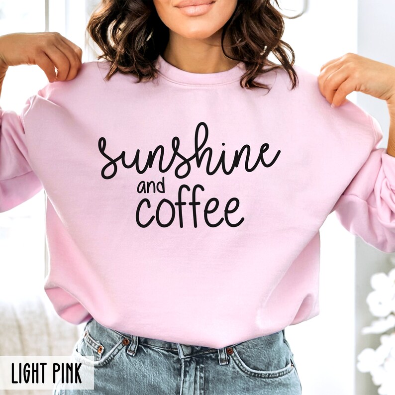 May include: A light pink sweatshirt with the text "sunshine and coffee" in black lettering.