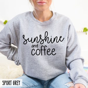 May include: A grey sweatshirt with the text "sunshine and coffee" in black lettering.