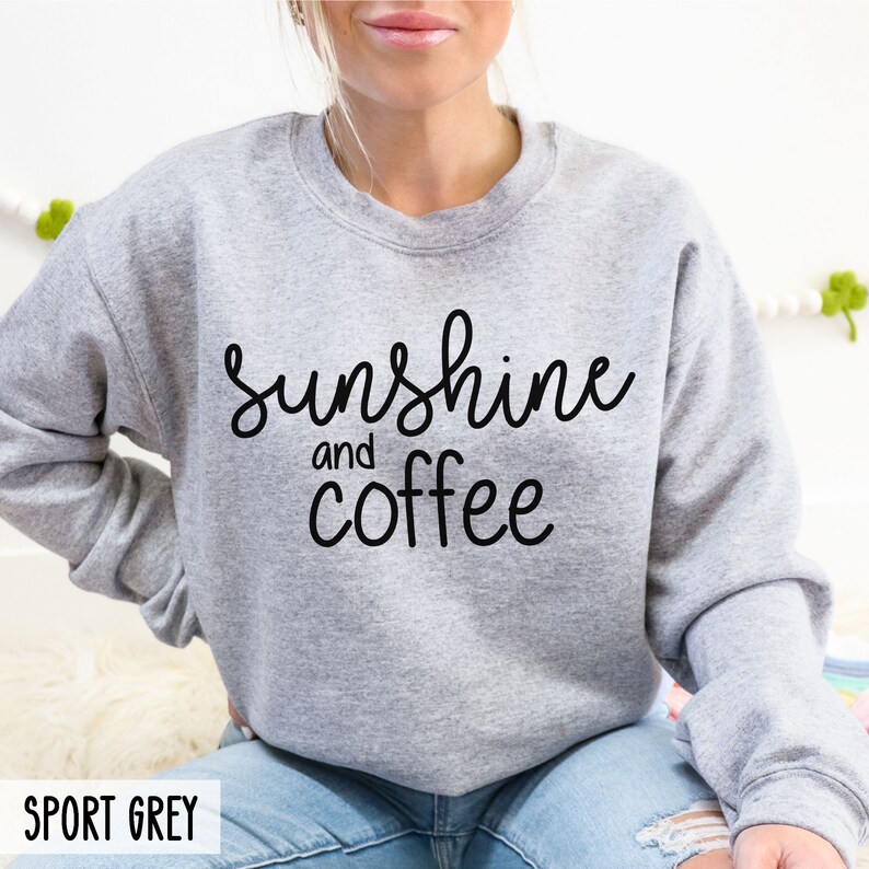 May include: A grey sweatshirt with the text "sunshine and coffee" in black lettering.