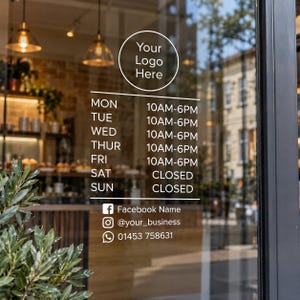 May include: A white vinyl window decal featuring a circular logo placeholder, business hours from Monday to Sunday, and contact information including Facebook, Instagram, and a phone number 01453 758631, applied to a glass storefront door.