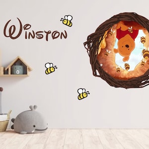 Könnte beinhalten: Ein Winnie Puuh Kinderzimmer Wandtattoo mit Winnie Puuh in einem Honigtopf, umgeben von Bienen. Das Wandtattoo enthält auch den Text "Winston" und mehrere Bienen.