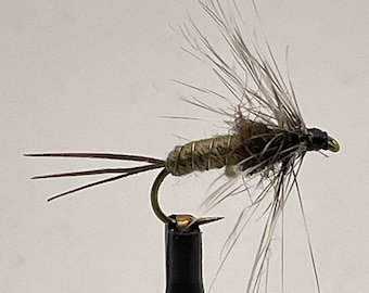 May include: A brown and gray fly fishing lure with a gold body and three tail feathers.
